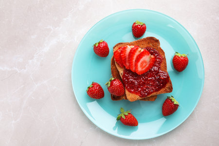 Toasts with jam and strawberries on light gray marble table, top view. healthy breakfastの写真素材