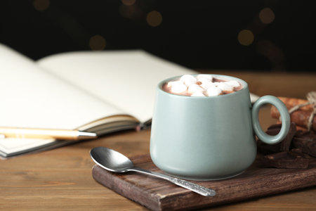 Delicious cocoa drink with marshmallows in cup on wooden tableの写真素材