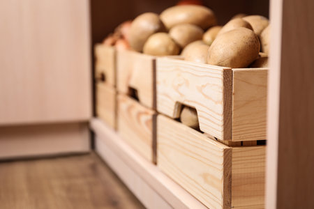 Crates with potatoes on shelf, closeup. Orderly storageの写真素材