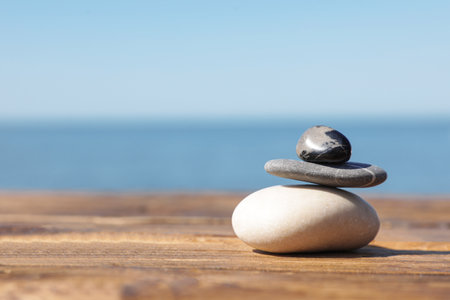 Stack of stones on wooden pier near sea, space for text. Zen conceptの写真素材
