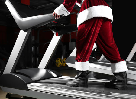 Authentic Santa Claus training on treadmill in modern gym, closeupの写真素材