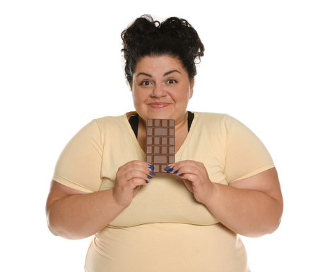 Happy overweight woman with chocolate on white backgroundの写真素材