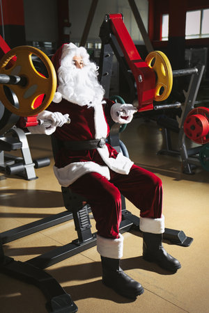 Young Santa Claus training in modern gymの写真素材