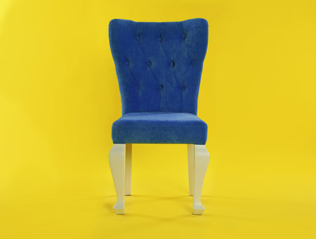 Stylish blue chair on yellow background. element of interior designの写真素材