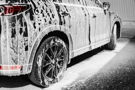 Luxury automobile covered with foam at car wash, closeupの写真素材