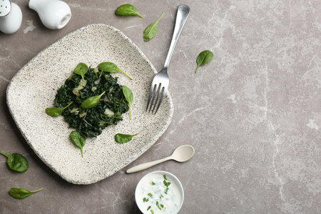 Flat lay composition with cooked spinach on gray marble table. Health foodの写真素材