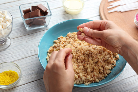Woman making tasty cake pops at white wooden table, closeupの写真素材