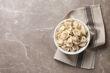 Tasty dumplings in bowl on marble table, flat lay. Space for textの写真素材
