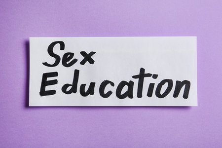 Piece of paper with phrase "SEX EDUCATION" on purple background, top viewの写真素材