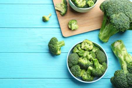 Flat lay composition of fresh green broccoli on blue wooden table, space for textの写真素材