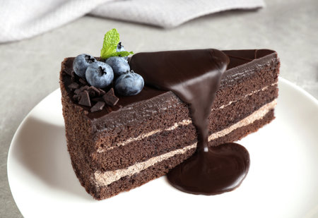 Delicious fresh chocolate cake with blueberries on light table, closeupの写真素材