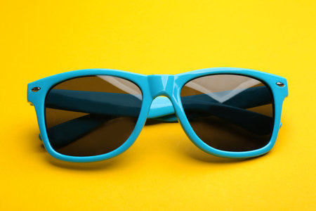 Stylish sunglasses on yellow background. fashion accessory