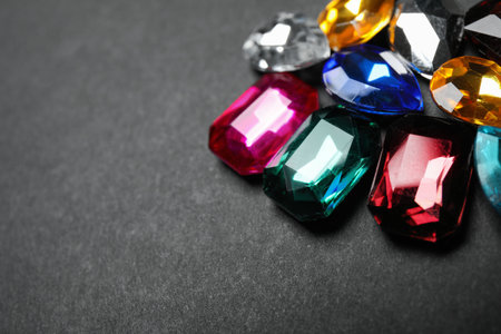 Pile of different beautiful gemstones on black background, closeup. Space for textの写真素材
