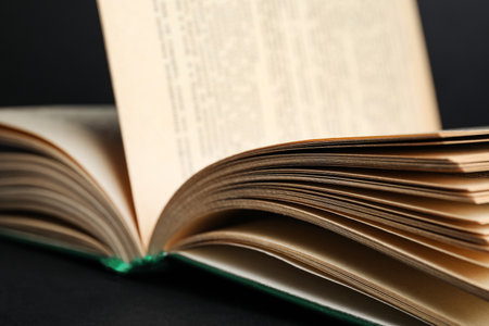 Close up view of open book on black background