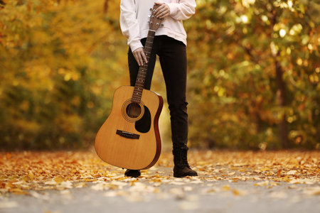 Teen girl with guitar in autumn park, closeupの写真素材