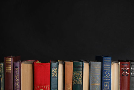 Stack of hardcover books on black background. Space for textの写真素材