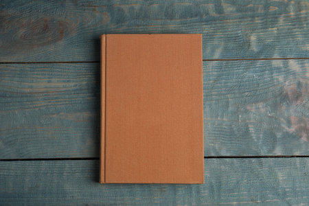 Hardcover book on light blue wooden table, top view. Space for textの写真素材