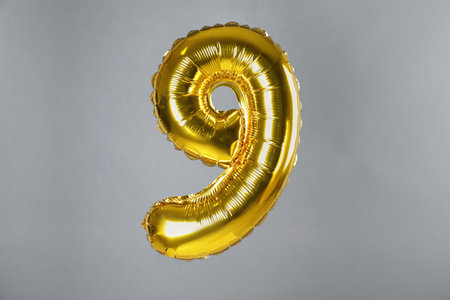 golden number nine balloon on gray backgroundの写真素材
