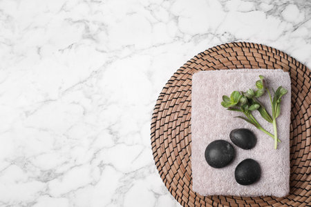 Flat lay composition with spa stones, towel and space for text on white marble backgroundの写真素材