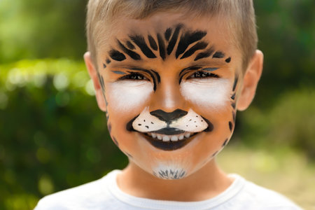 Cute little boy face painting outdoorsの写真素材