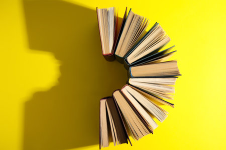 Hardcover books on yellow background, flat lay. Space for textの写真素材
