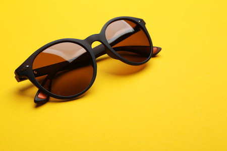 Stylish sunglasses on yellow background. fashion accessoryの写真素材