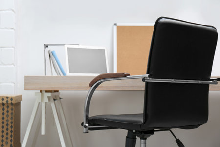 Stylish workplace interior with office chair and wooden tableの写真素材