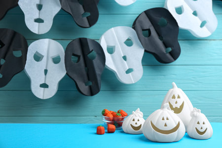 Jack-o-Lantern holders and candies on light blue table against decorated wooden background. halloween decorの写真素材