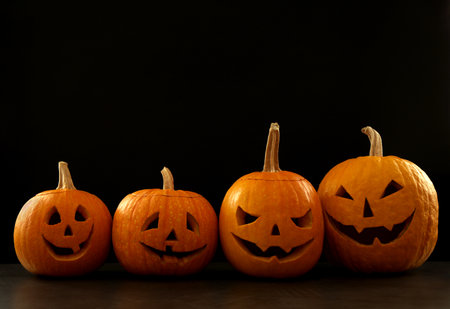 Spooky Jack pumpkin head lanterns on gray table against black background, space for text. halloween decorationの写真素材