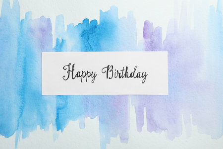 Card with words HAPPY BIRTHDAY on watercolor painting, top viewの写真素材