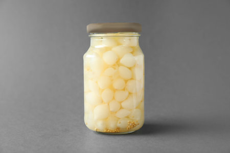 Jar of pickled onions on gray backgroundの写真素材