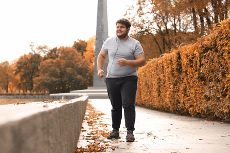 Young overweight man running in the park. fitness lifestyleの写真素材