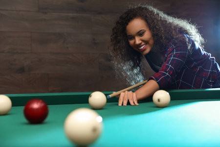 Young African-American woman playing billiard indoorsの写真素材