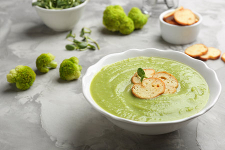 Bowl of broccoli cream soup with croutons served on gray tableの写真素材