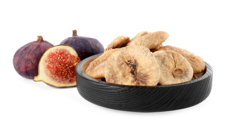 Black wooden plate of dried figs and fresh fruits on white backgroundの写真素材