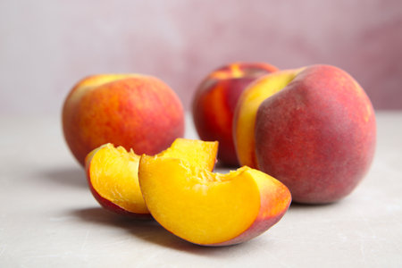 Cut and whole juicy peaches on light tableの写真素材