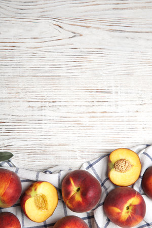 Tasty fresh peaches and fabric on white wooden table, flat lay. Space for textの写真素材