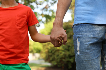 Little boy and his father holding hands outdoors, closeup. family weekendの写真素材