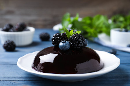 Delicious fresh jelly with berries on blue wooden tableの写真素材