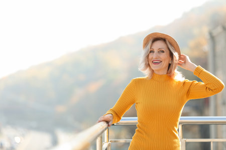 Portrait of happy mature woman on balcony, outdoorsの写真素材