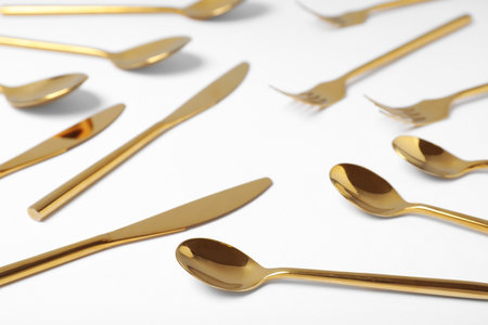 Set of new gold cutlery on white backgroundの写真素材