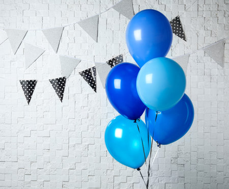 Blue balloons near white wall decorated with flag garlands. greeting cardの写真素材