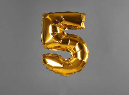 golden number five balloon on gray backgroundの写真素材