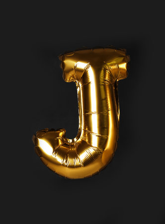 Golden letter J balloon on black backgroundの写真素材