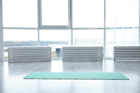 Unrolled light blue yoga mat on floor in roomの写真素材