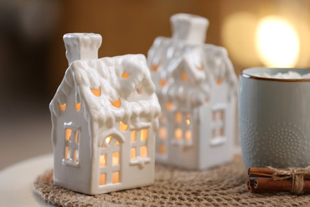 Composition with house shaped candle holder on white table against blurred background. christmas decorationの写真素材