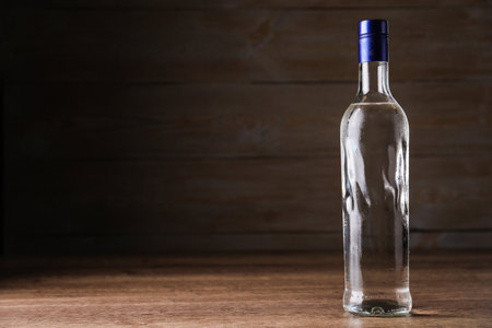 Bottle of vodka on table against wooden background. Space for textの写真素材