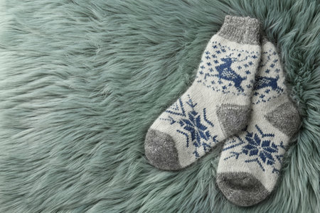 Knitted socks on gray faux fur, flat lay. Space for textの写真素材