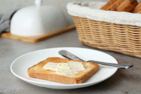 Slice of toasted bread with butter on gray tableの写真素材