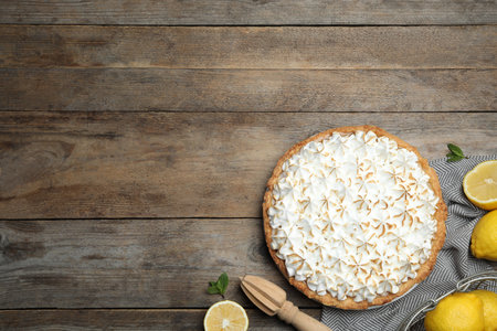 Flat lay composition with delicious lemon meringue pie on wooden table, space for textの写真素材